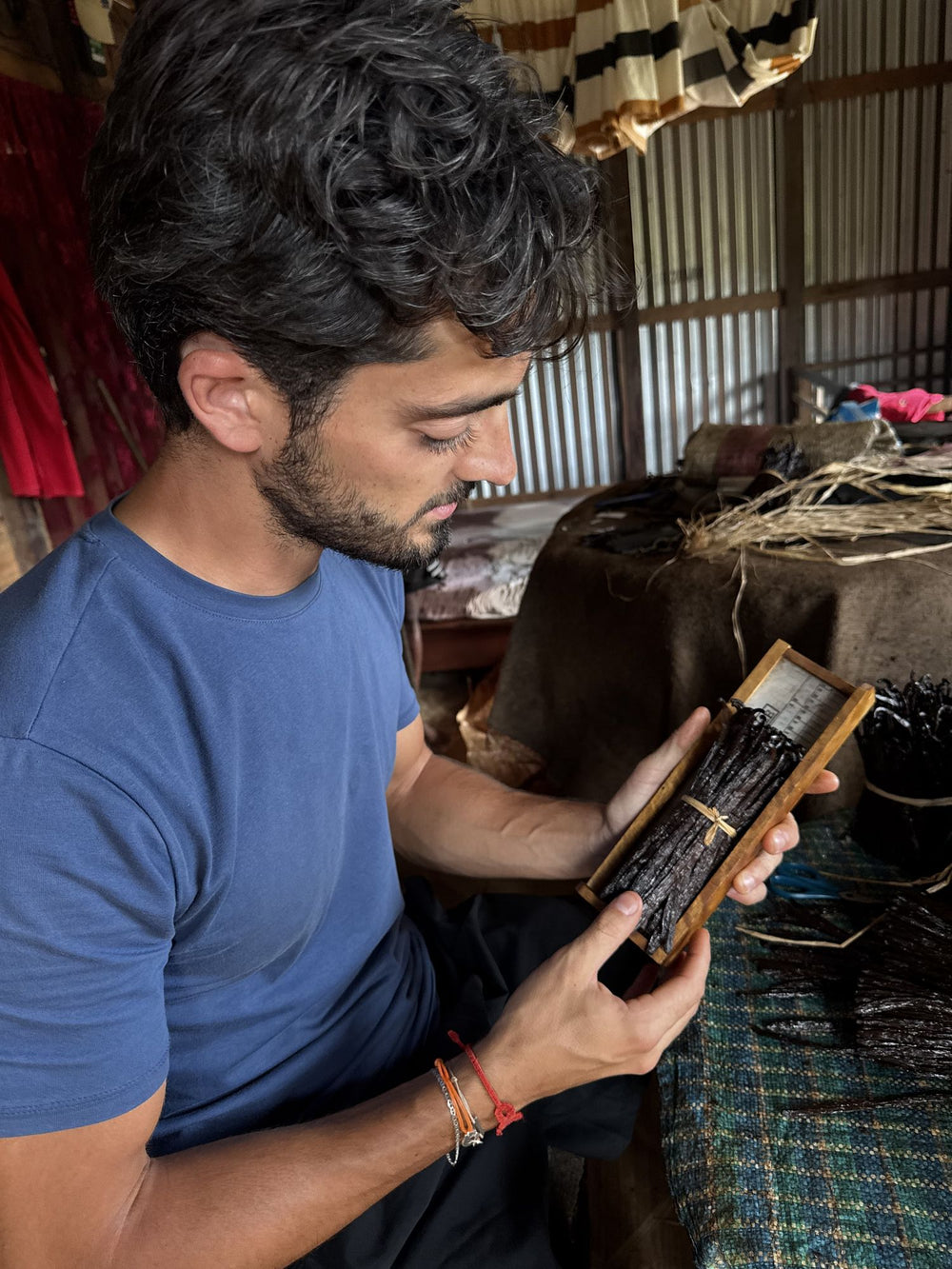 Paul Charles, fondateur de Comptoir Manitra, sent une botte de vanille à l'atelier, à Madagascar
